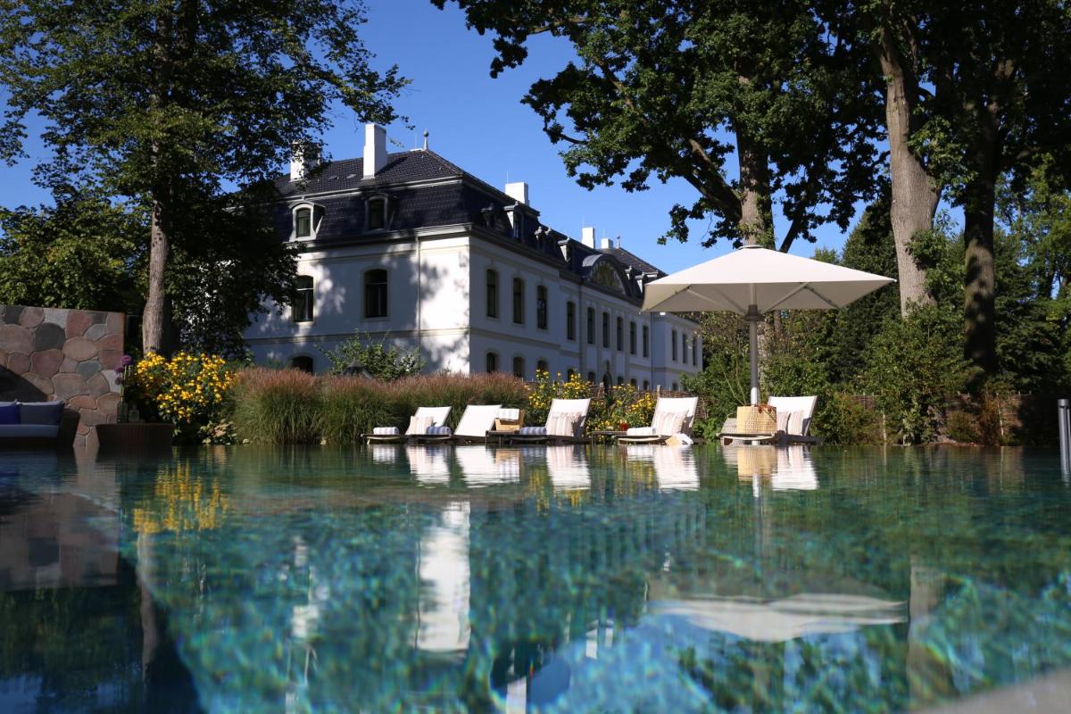 Ein Haus mit Swimmingpool, Liegestühlen und Sonnenschirm in der Unterkunft Weissenhaus Private Nature Luxury Resort in Weißenhaus