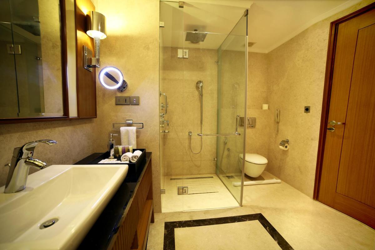 a bathroom with a shower and a sink and a toilet at Ramada Plaza Chennai in Chennai