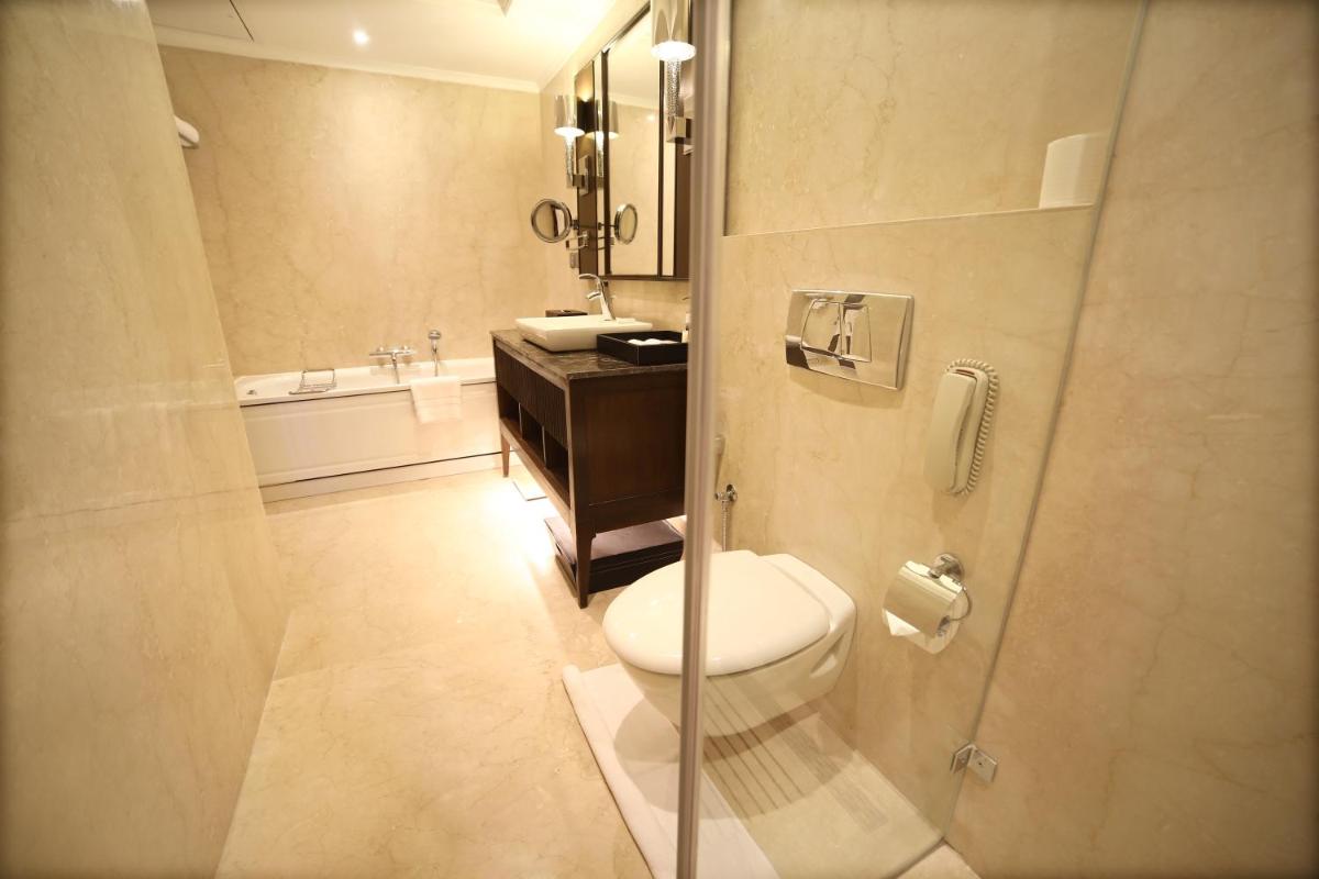 a bathroom with a toilet and a sink at Ramada Plaza Chennai in Chennai