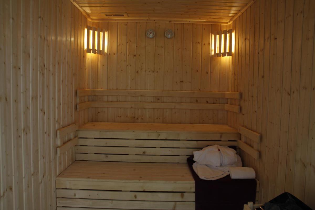 uma sauna com um banco e duas luzes em Palace Hotel & SPA Termas do Bicanho em Soure
