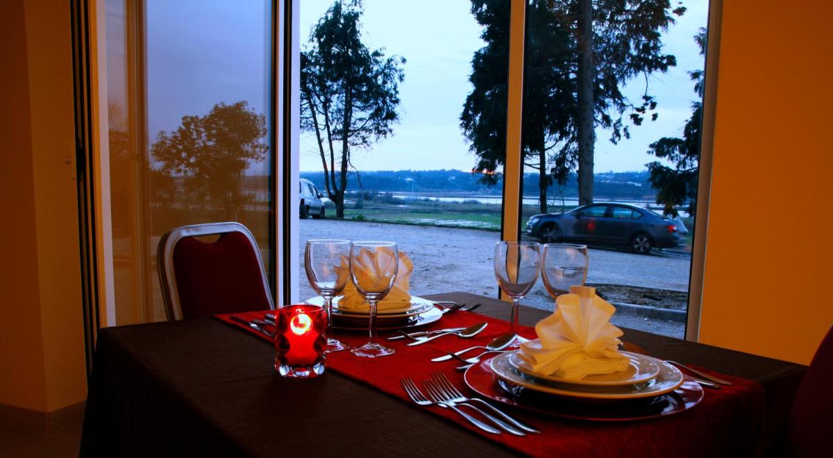 uma mesa com uma toalha de mesa vermelha e copos de vinho em Palace Hotel & SPA Termas do Bicanho em Soure