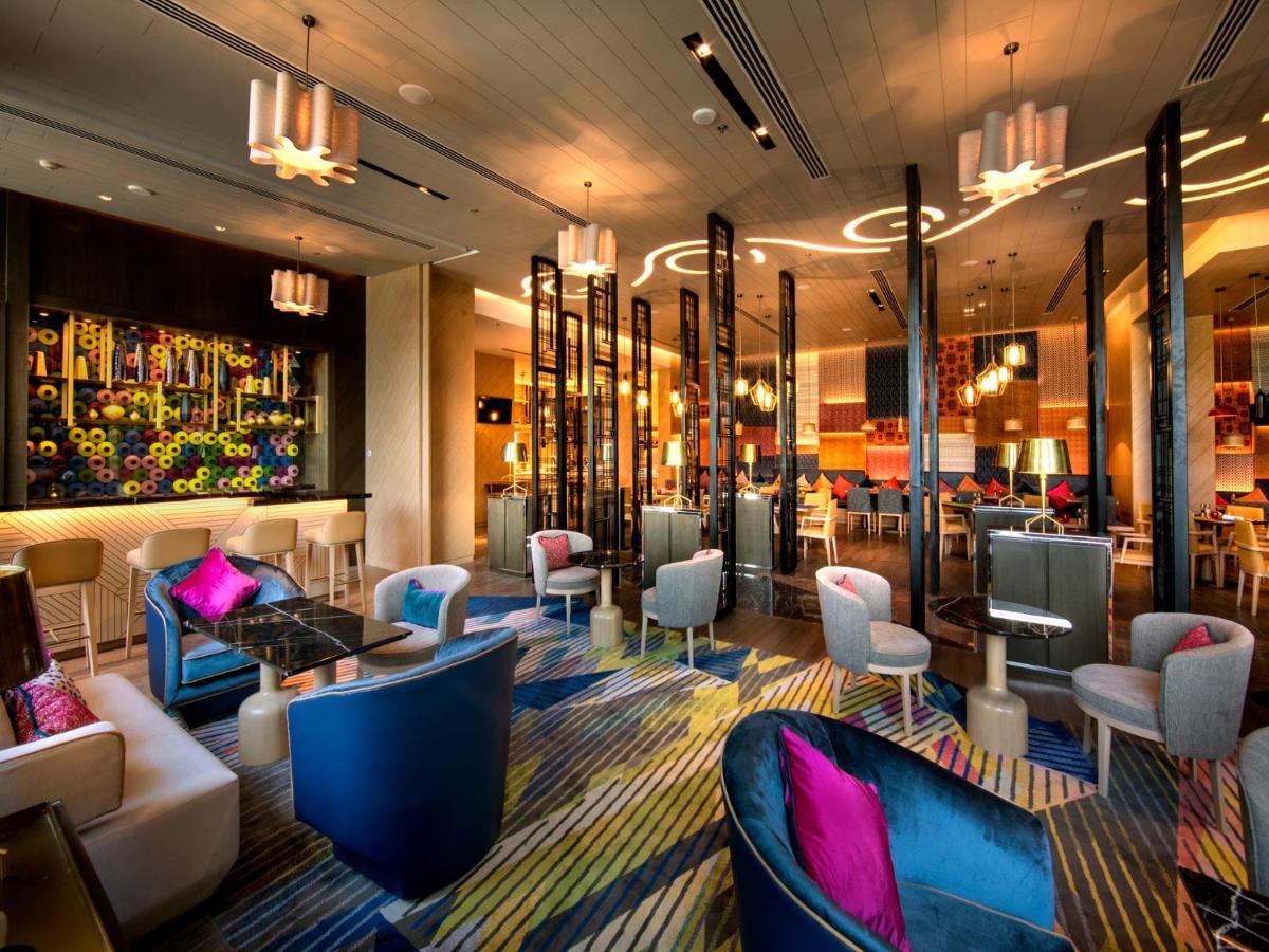 a lobby with chairs and tables and a bar at Welcomhotel by ITC Hotels, RaceCourse, Coimbatore in Coimbatore