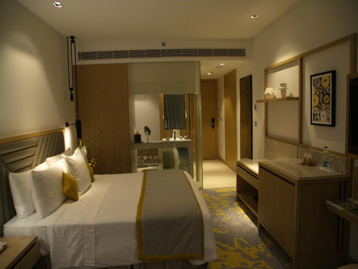 a hotel room with a large bed and a bathroom at Welcomhotel by ITC Hotels, RaceCourse, Coimbatore in Coimbatore