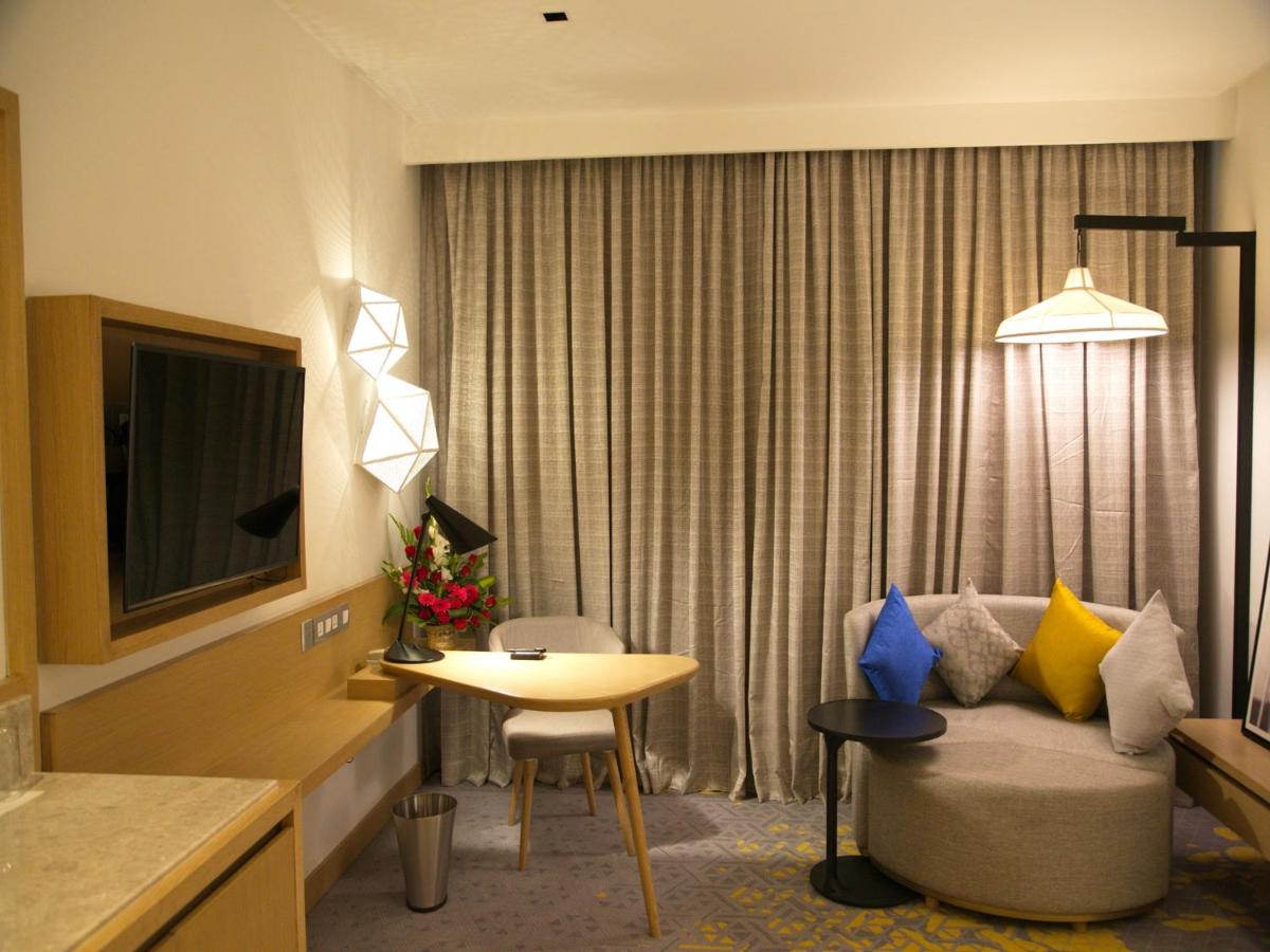 a hotel room with a couch and a table at Welcomhotel by ITC Hotels, RaceCourse, Coimbatore in Coimbatore