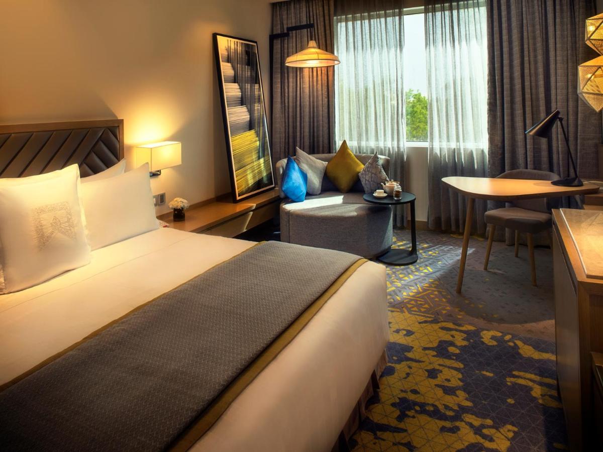 a hotel room with a large bed and a desk at Welcomhotel by ITC Hotels, RaceCourse, Coimbatore in Coimbatore
