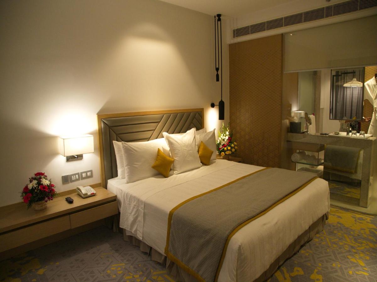 a hotel room with a large bed and a bathroom at Welcomhotel by ITC Hotels, RaceCourse, Coimbatore in Coimbatore