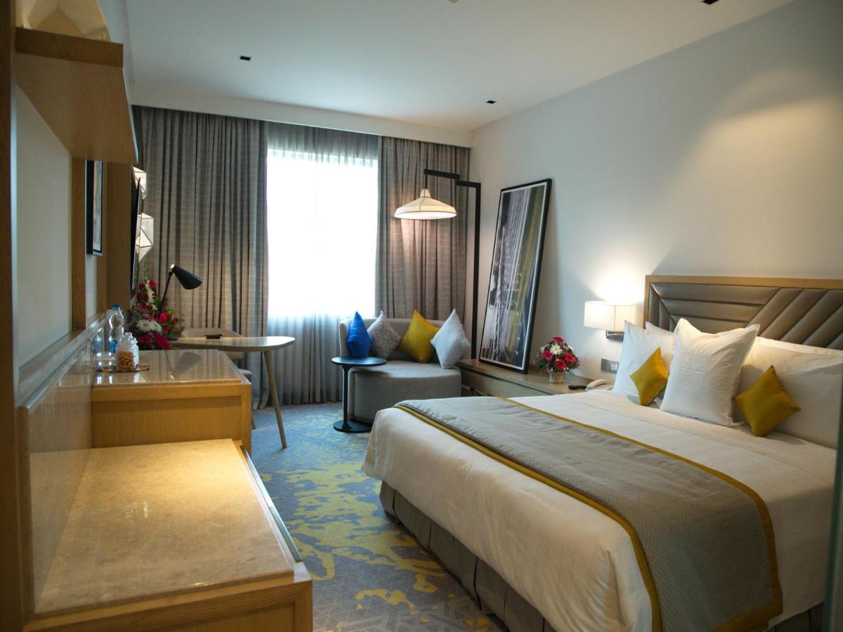 a hotel room with a large bed and a window at Welcomhotel by ITC Hotels, RaceCourse, Coimbatore in Coimbatore