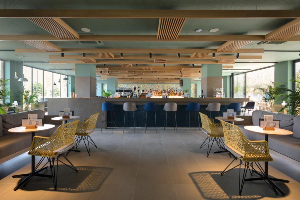 Un restaurante con mesas y sillas y un bar. en AQUA Hotel Silhouette & Spa - Adults Only, en Malgrat de Mar