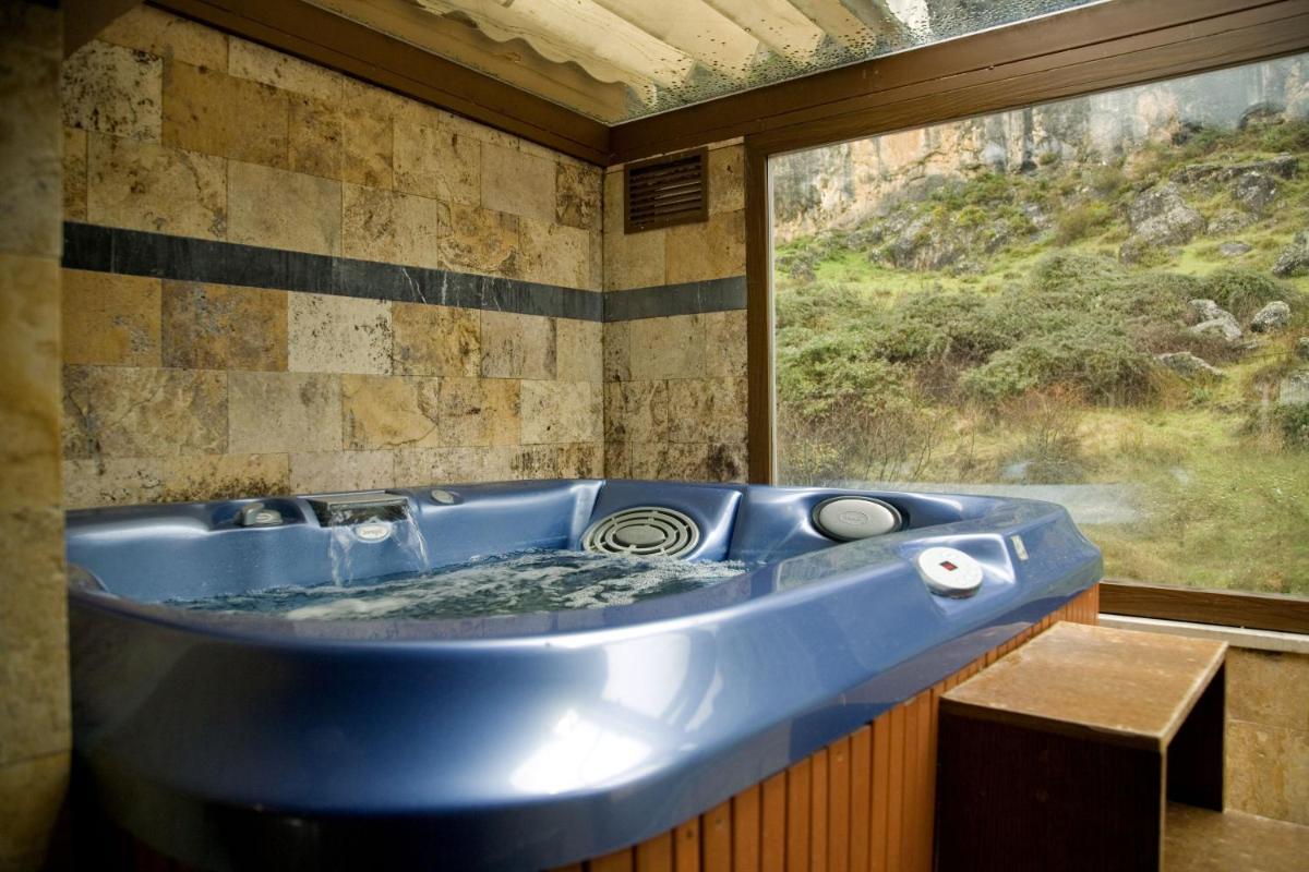bañera azul en una habitación con ventana en Hotel & Spa Sierra de Cazorla 4*, en Cazorla