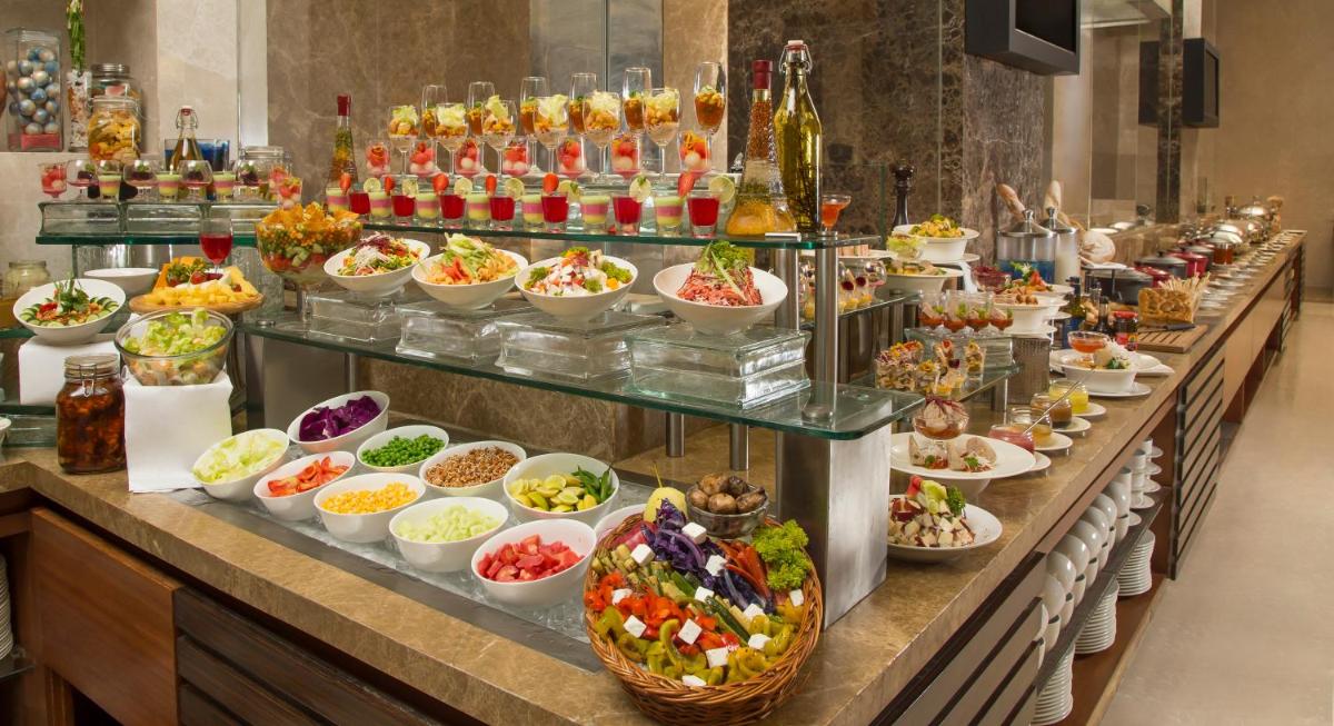 a buffet line with many different dishes of food at Radisson Blu Hotel Ahmedabad in Ahmedabad