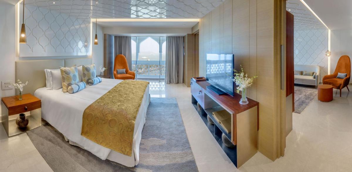 a hotel room with a large bed and a desk at The Taj Mahal Tower, Mumbai in Mumbai