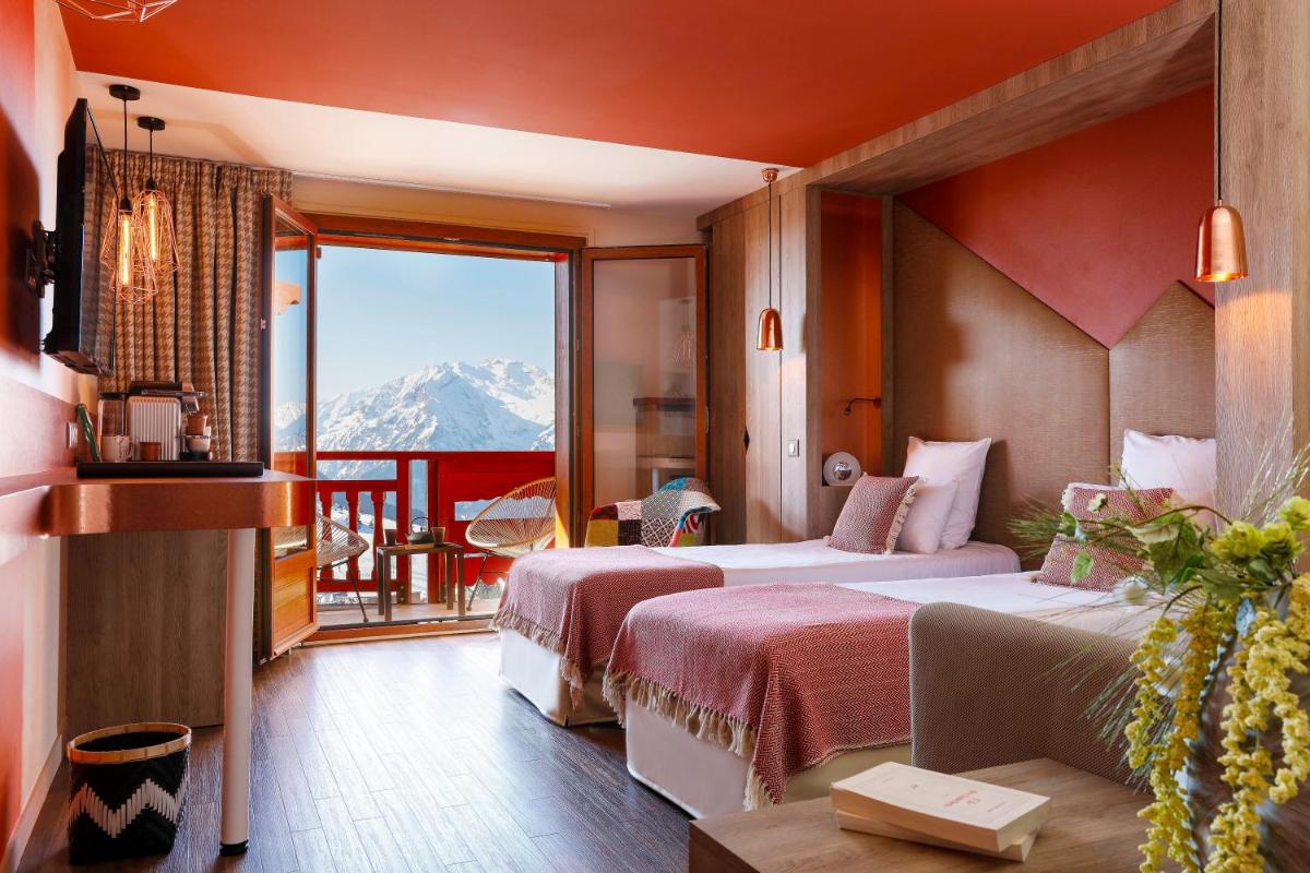 une chambre d'hôtel avec deux lits et un balcon dans l'établissement Grandes Rousses Hotel & Spa, à L'Alpe-d'Huez 37 autres photos