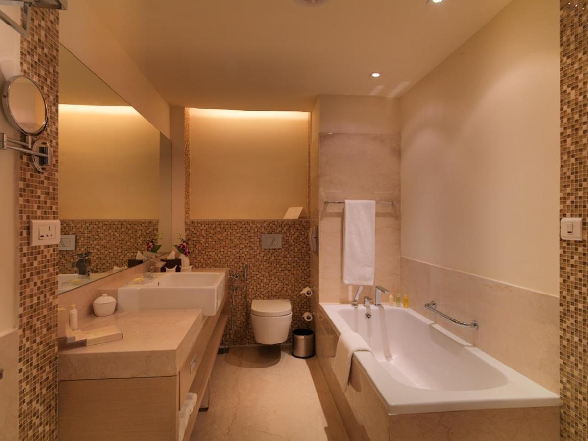 a bathroom with a tub and a toilet and a sink at Radisson Blu Hotel, Greater Noida in Greater Noida