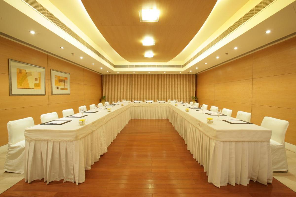 a large room with long tables and white chairs at Jaypee Siddharth in New Delhi a large room with long tables and white chairs at Jaypee Siddharth in New Delhi