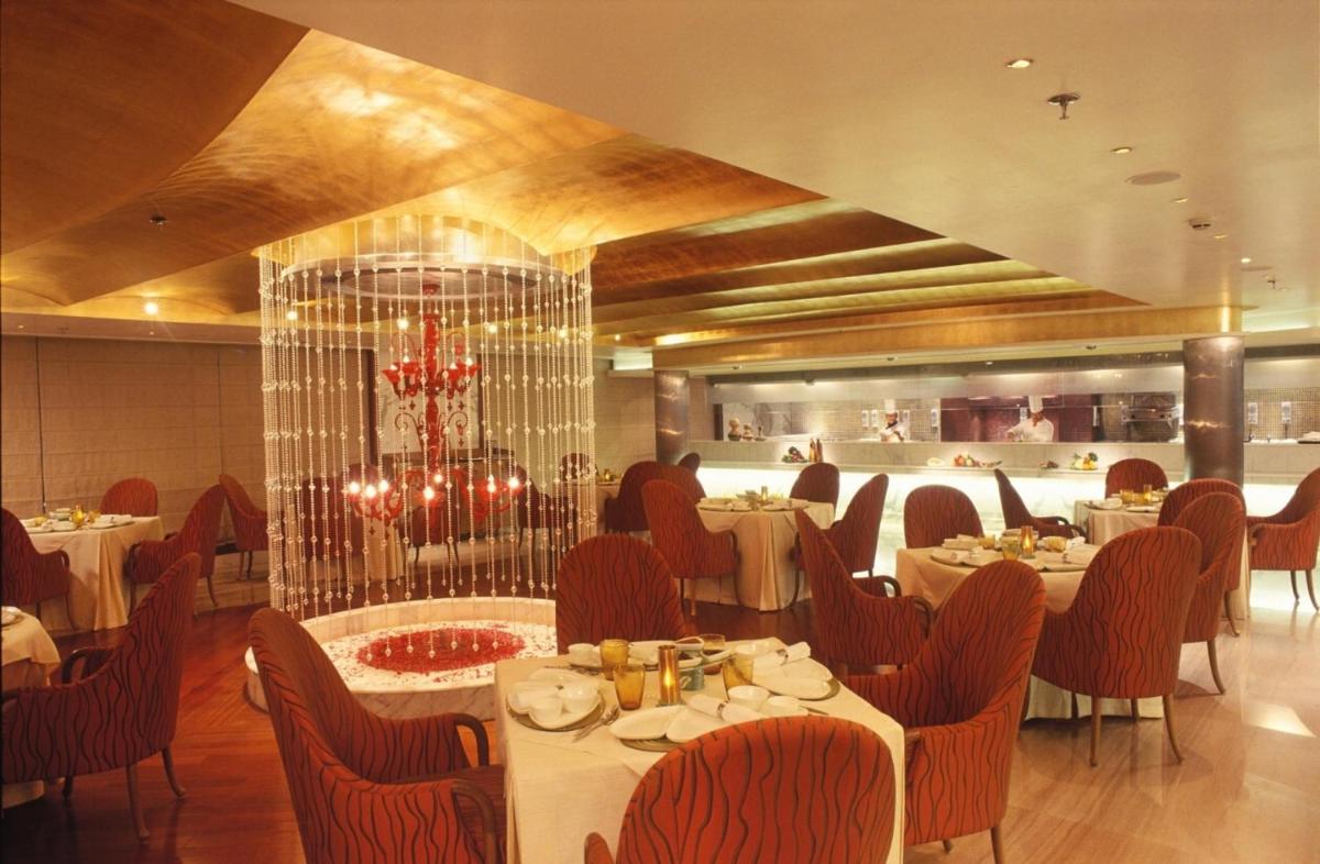 a restaurant with tables and chairs in a room at Jaypee Siddharth in New Delhi a restaurant with tables and chairs in a room at Jaypee Siddharth in New Delhi