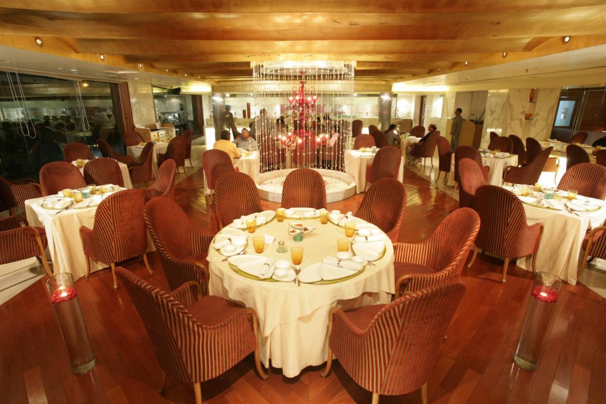 a banquet room with tables and chairs and a chandelier at Jaypee Siddharth in New Delhi a banquet room with tables and chairs and a chandelier at Jaypee Siddharth in New Delhi