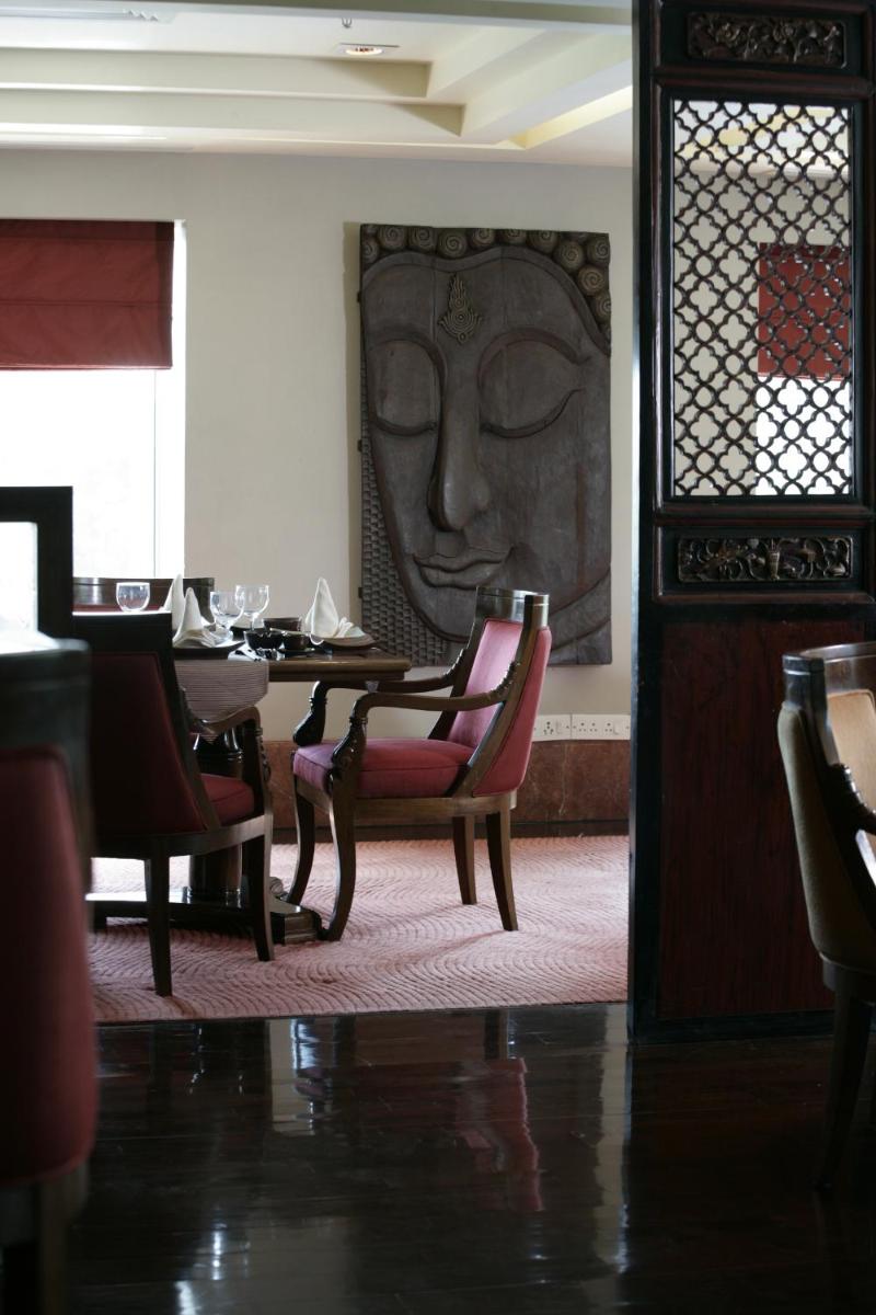 a dining room with a table with a face on the wall at Jaypee Vasant Continental in New Delhi