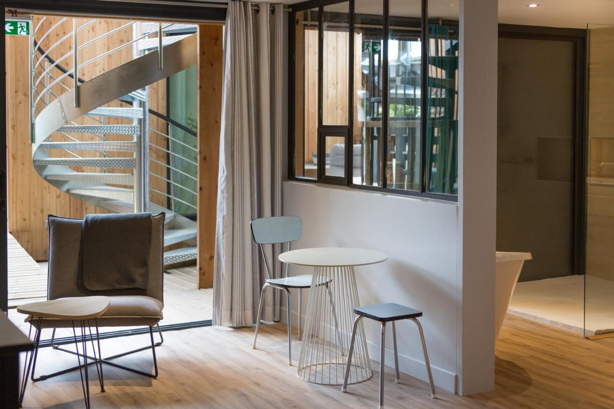 une pièce avec une table, des chaises et un escalier dans l'établissement Le Miel des Muses, à Brive-la-Gaillarde