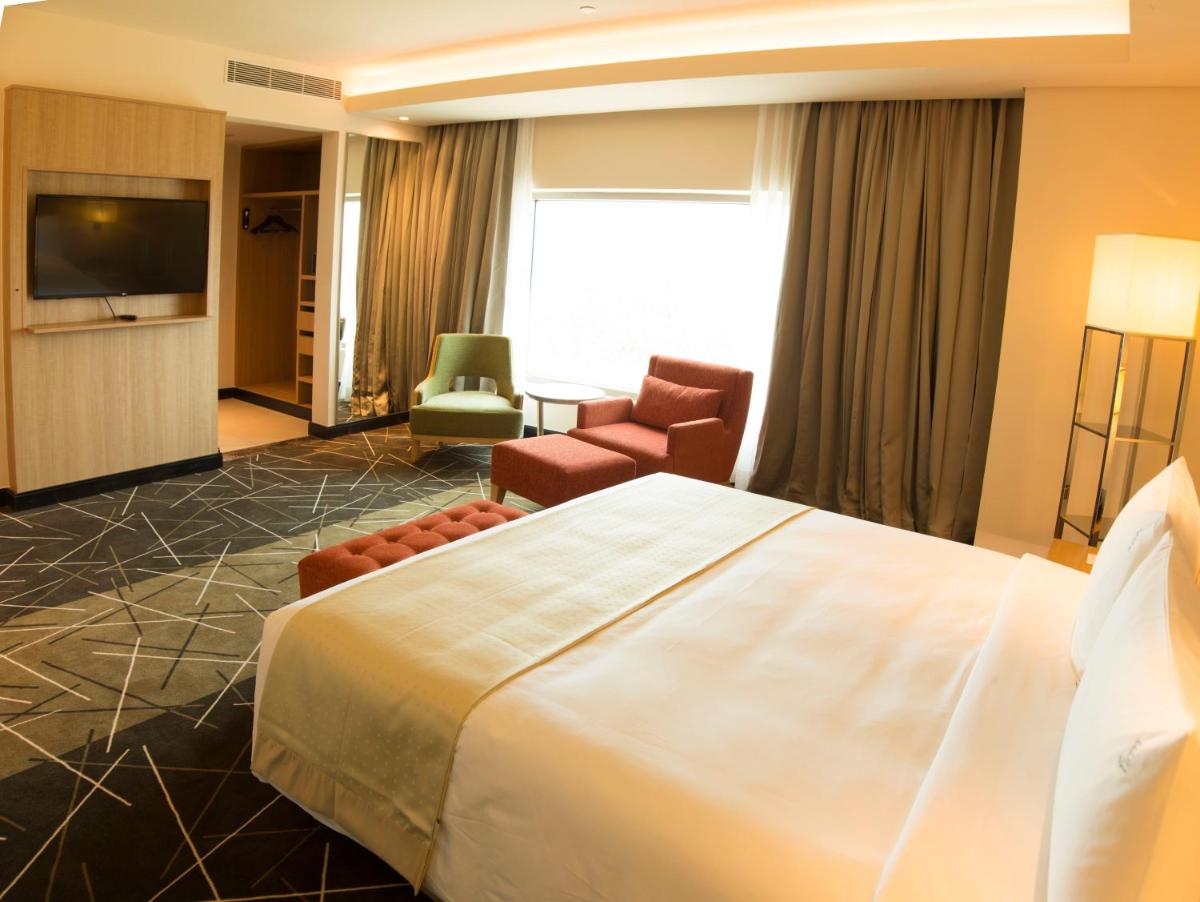 a hotel room with a large bed and a television at Holiday Inn Chennai OMR IT Expressway by IHG in Chennai