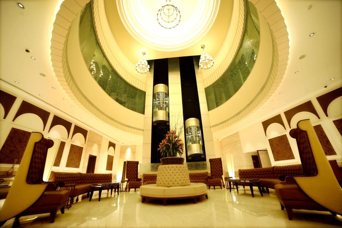 a lobby with a building with a space shuttle on a column at Ramada Plaza Chennai in Chennai
