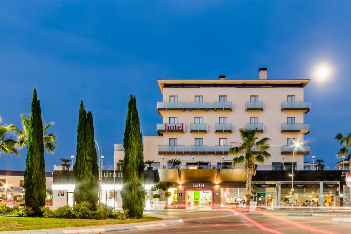 Un hotel con un estacionamiento enfrente. en Hotel 525, en Los Alcázares