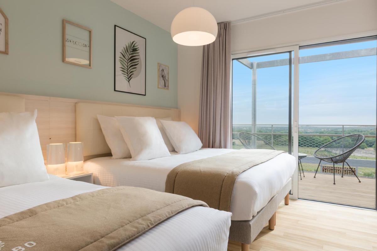 Un ou plusieurs lits dans un hébergement de l'établissement Hôtel Omnubo Collection