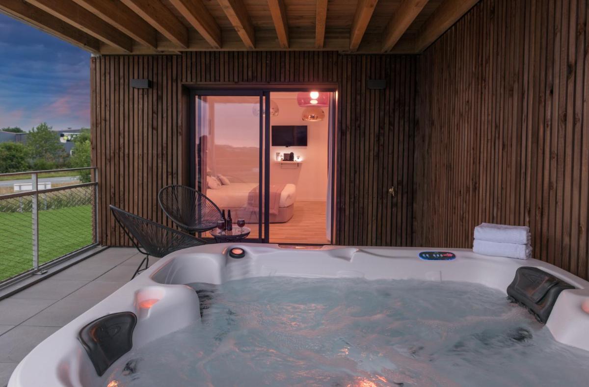 Cette chambre dispose d'un balcon et d'une baignoire. dans l'établissement Hôtel Omnubo Collection, aux Épesses