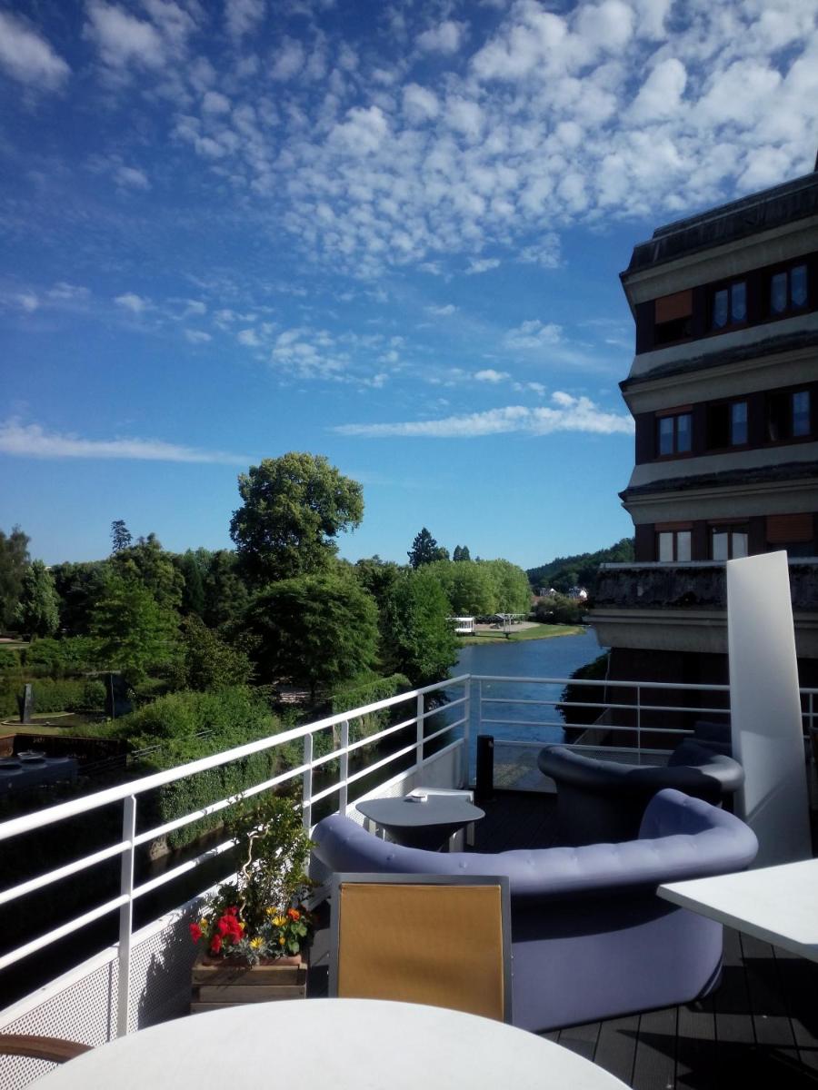 un balcon avec des chaises et une vue sur une rivière dans l'établissement Mercure Epinal Centre, à Épinal