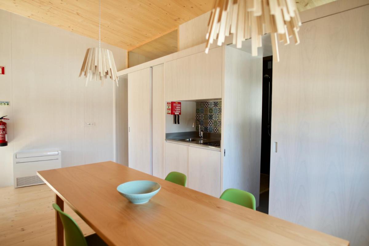 uma sala de jantar com uma mesa de madeira e cadeiras verdes em Bukubaki Eco Surf em Ferrel