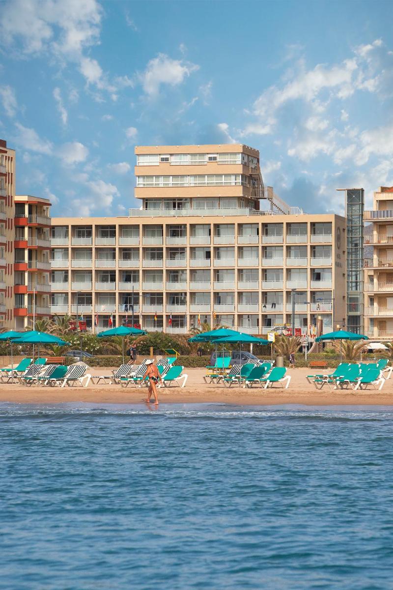 un hotel en una playa con sillas y sombrillas en Hotel Panorama, en L'Estartit