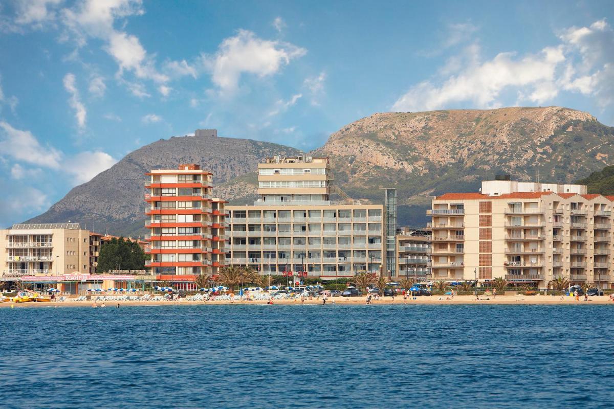 una playa con edificios y una montaña en el fondo en Hotel Panorama, en L'Estartit