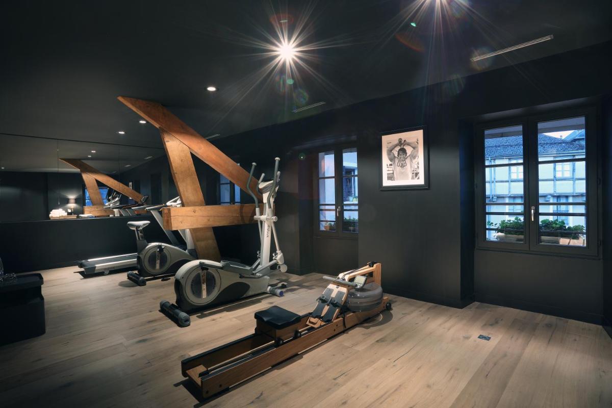 une salle de sport avec plusieurs appareils de musculation dans une pièce dans l'établissement Petit Hôtel Confidentiel, à Chambéry