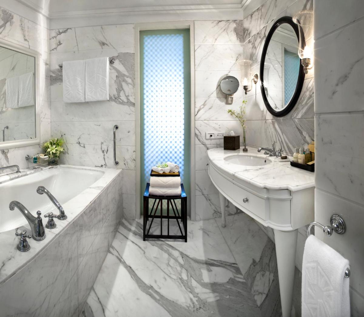 a white bathroom with a tub and a sink at The Taj Mahal Palace, Mumbai in Mumbai