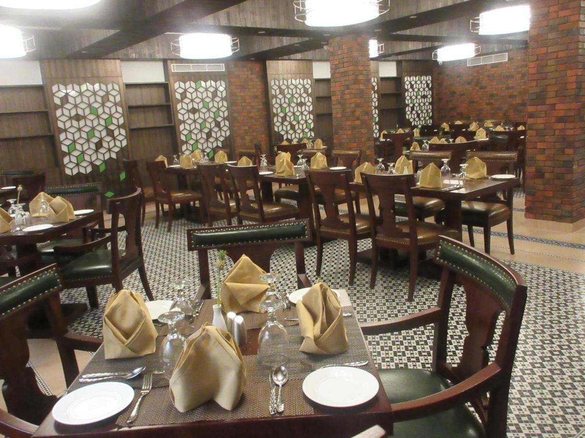 a dining room with tables and chairs with yellow napkins at Fragrant Nature Kochi - A Five star Classified Hotel in Cochin