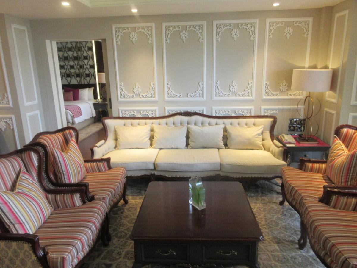 a living room with a couch and chairs and a table at Fragrant Nature Kochi - A Five star Classified Hotel in Cochin