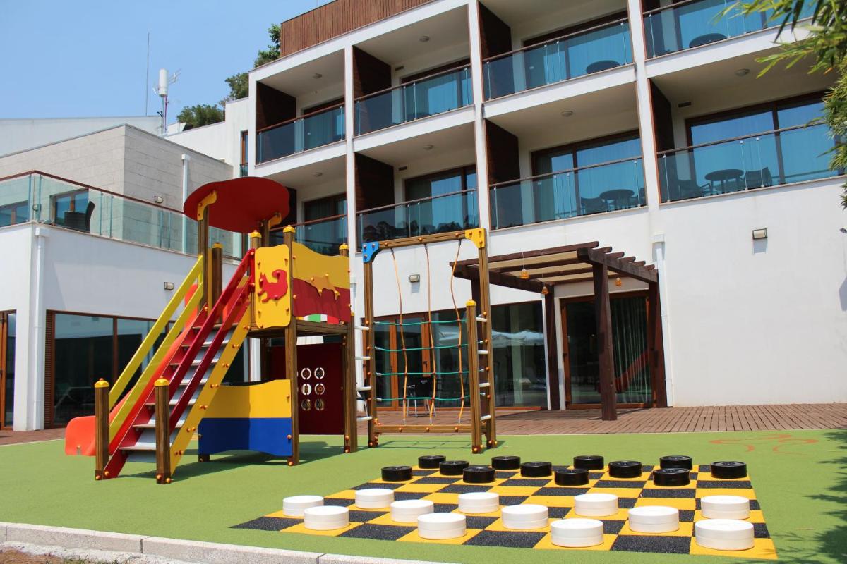 um playground em frente a um prédio com um escorregador em Hotel Rural Vale Do Rio em Oliveira de Azemeis