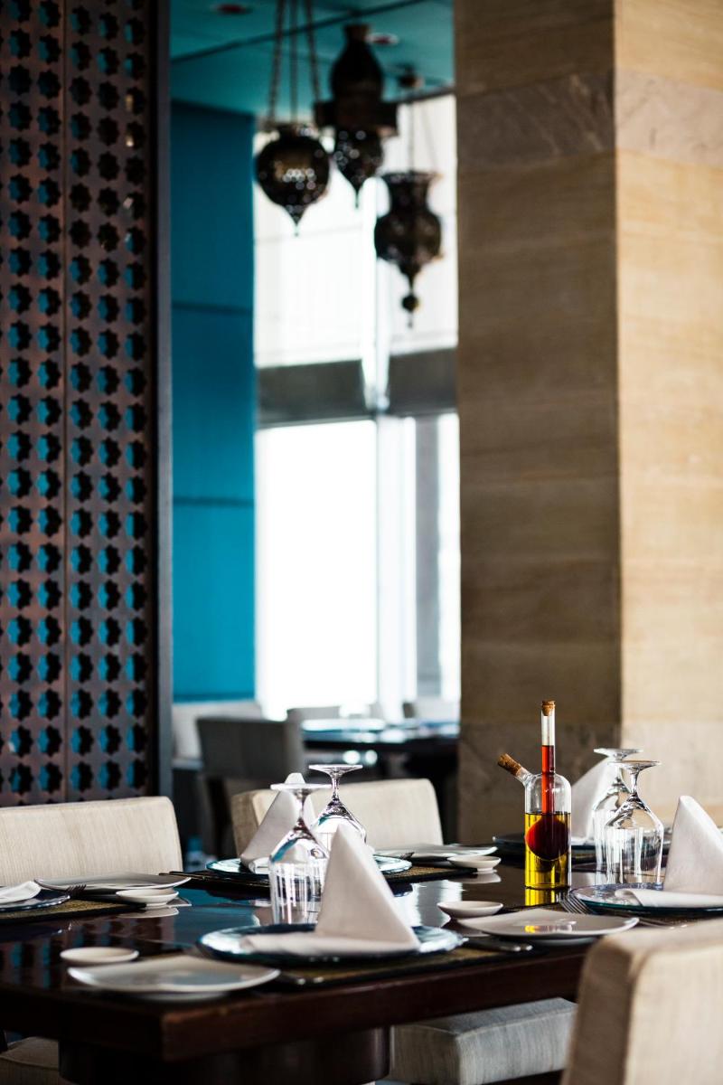 a dining room with a table with plates and napkins at The Taj Mahal Palace, Mumbai in Mumbai a dining room with a table with plates and napkins at The Taj Mahal Palace, Mumbai in Mumbai