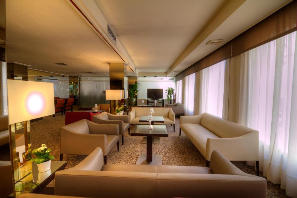 Una sala de estar con sofás, una mesa y ventanas. en Hotel Royal Plaza, en Ibiza