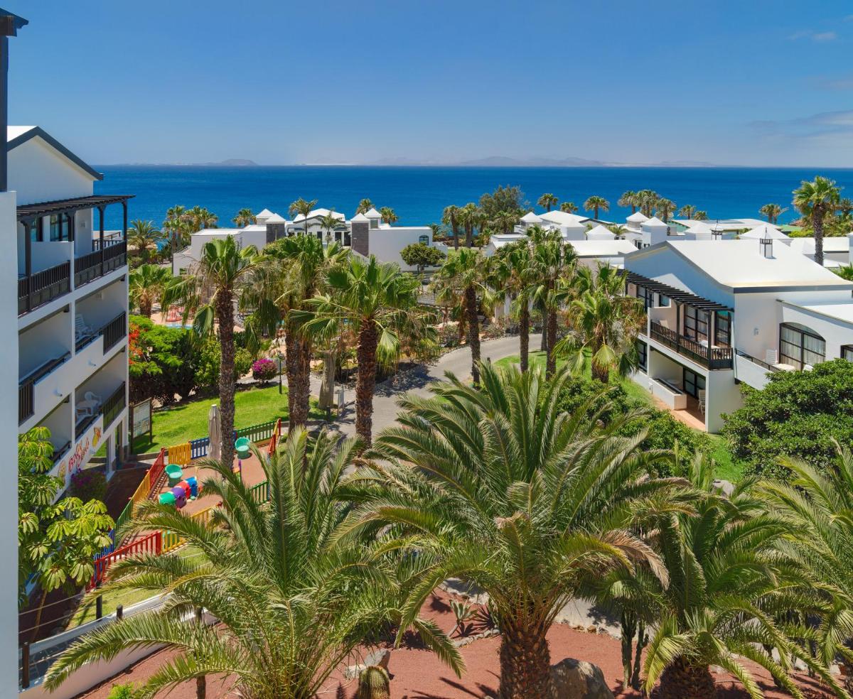 Una vista aérea de un resort con palmeras y el océano. en H10 Rubicón Horizons Collection, en Playa Blanca