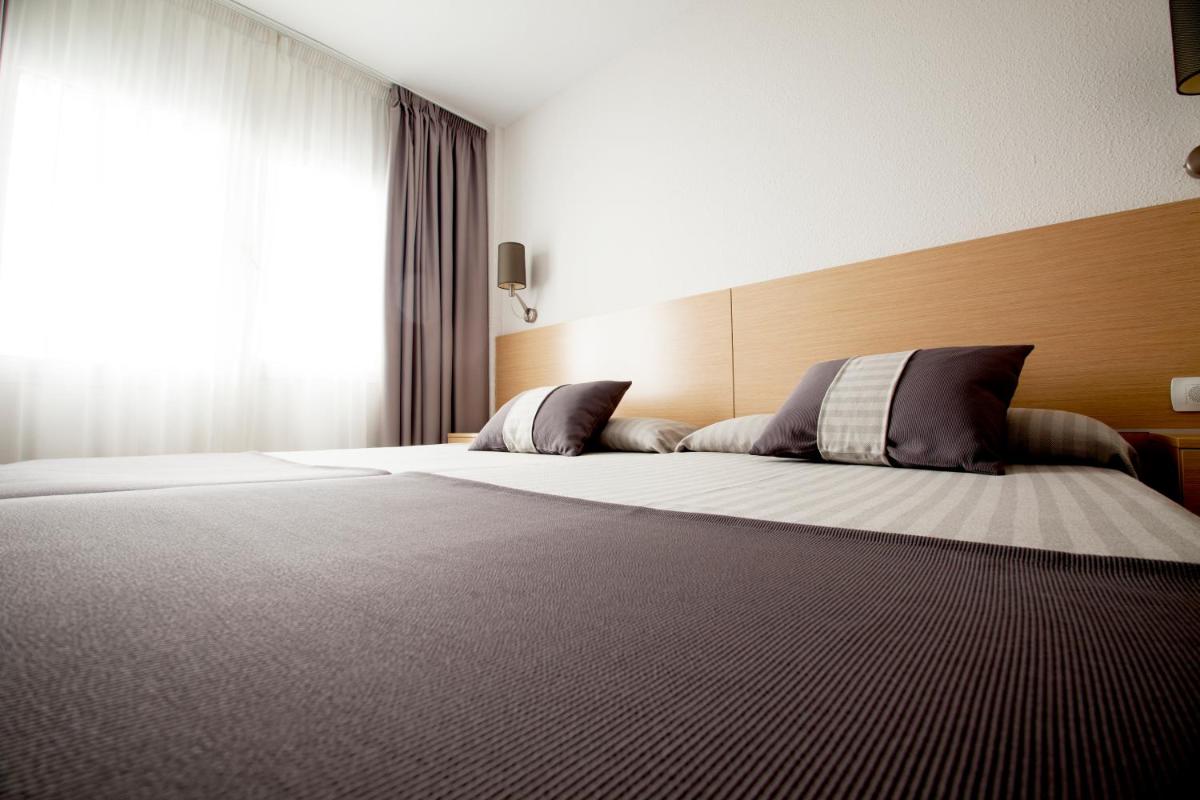 Un dormitorio con una cama grande y una ventana. en Aparthotel Acuazul, en Peñíscola