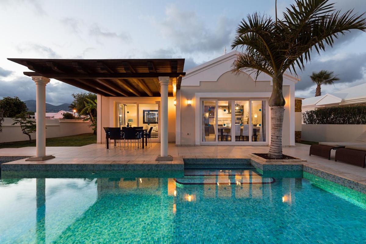 una villa con piscina y una casa en Villas Alondra, en Puerto del Carmen