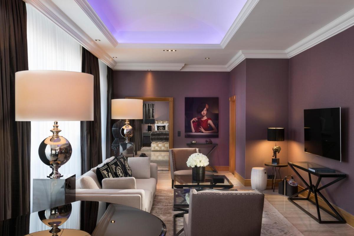 ein Wohnzimmer mit lilafarbenen Wänden und einer Decke in der Unterkunft Hotel Palace Berlin in Berlin