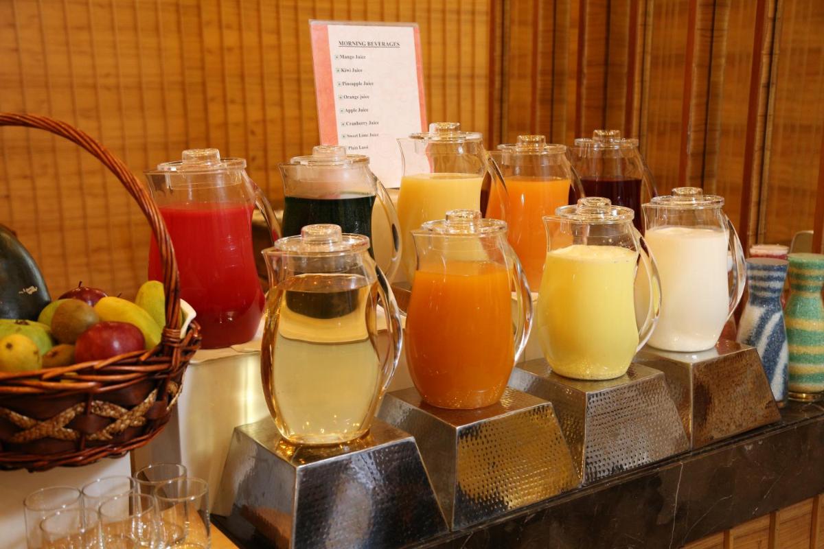 a bunch of different types of drinks in glass pitchers at The Metropolitan Hotel & Spa New Delhi in New Delhi