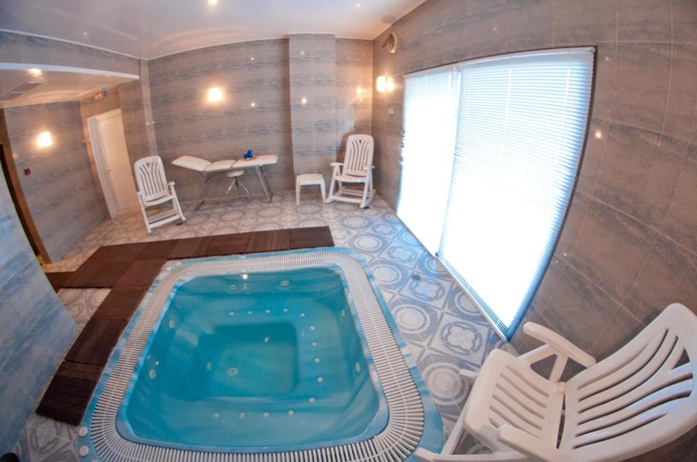 Una piscina en una casa con una mesa y sillas. en Hotel Cala Gat, en Cala Ratjada