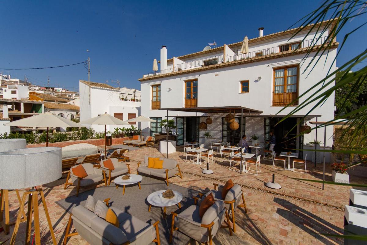Un patio con sillas y mesas frente a un edificio. en La Serena Boutique Hotel & Wellness - Altea, en Altea