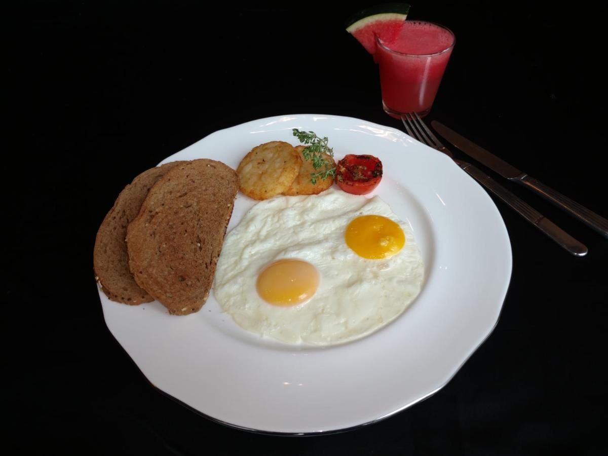 a white plate with eggs and bread and toast at Vivanta Hyderabad, Begumpet in Hyderabad a white plate with eggs and bread and toast at Vivanta Hyderabad, Begumpet in Hyderabad