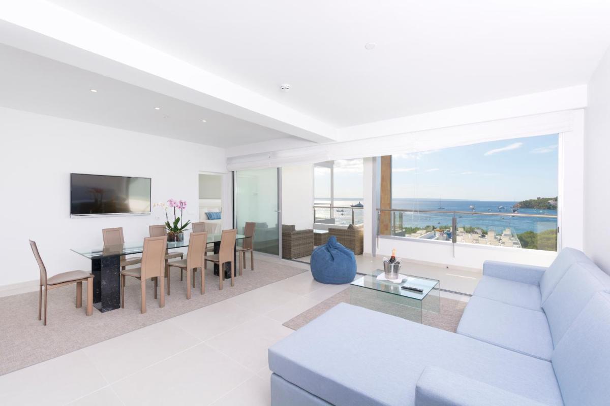 Una sala de estar con un sofá blanco y una mesa con vista. en Reverence Mare Hotel - Adults Only, en Palmanova