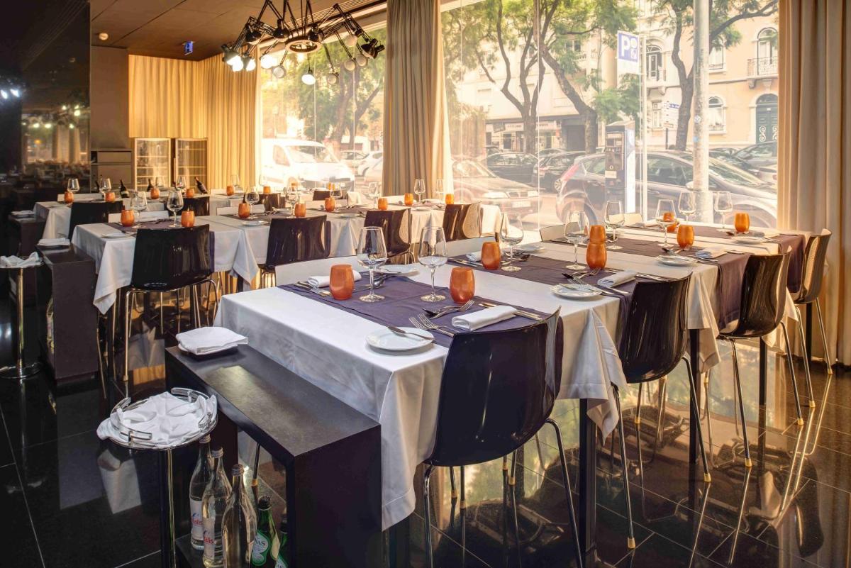 um grupo de mesas num quarto com uma janela em VIP Grand Lisboa Hotel & Spa em Lisboa