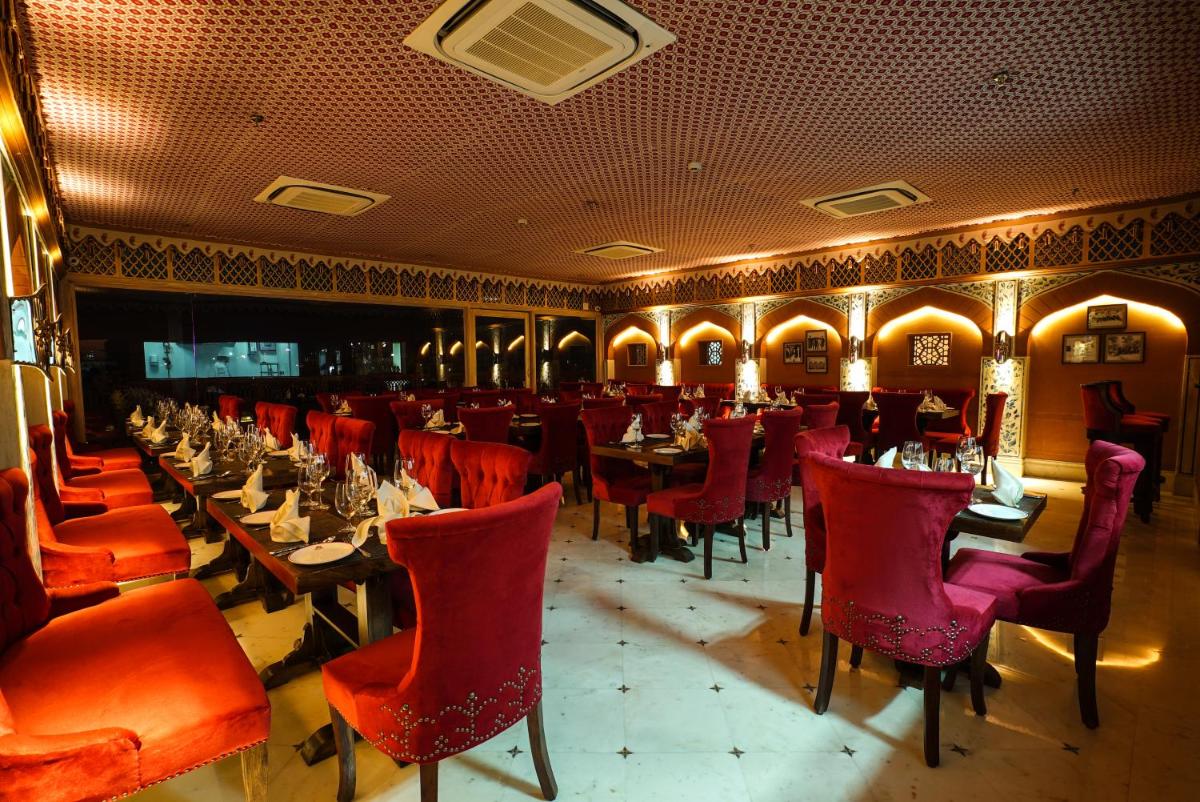 a dining room with tables and red chairs at Shahpura House in Jaipur