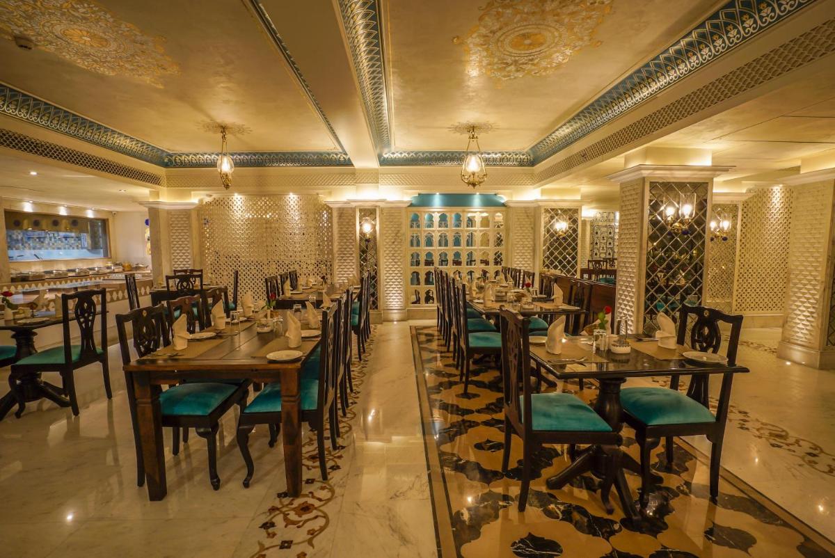 a restaurant with tables and chairs in a room at Shahpura House in Jaipur